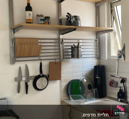 מדפים עם כלים, סכינים תלויים, קרש חיתוך